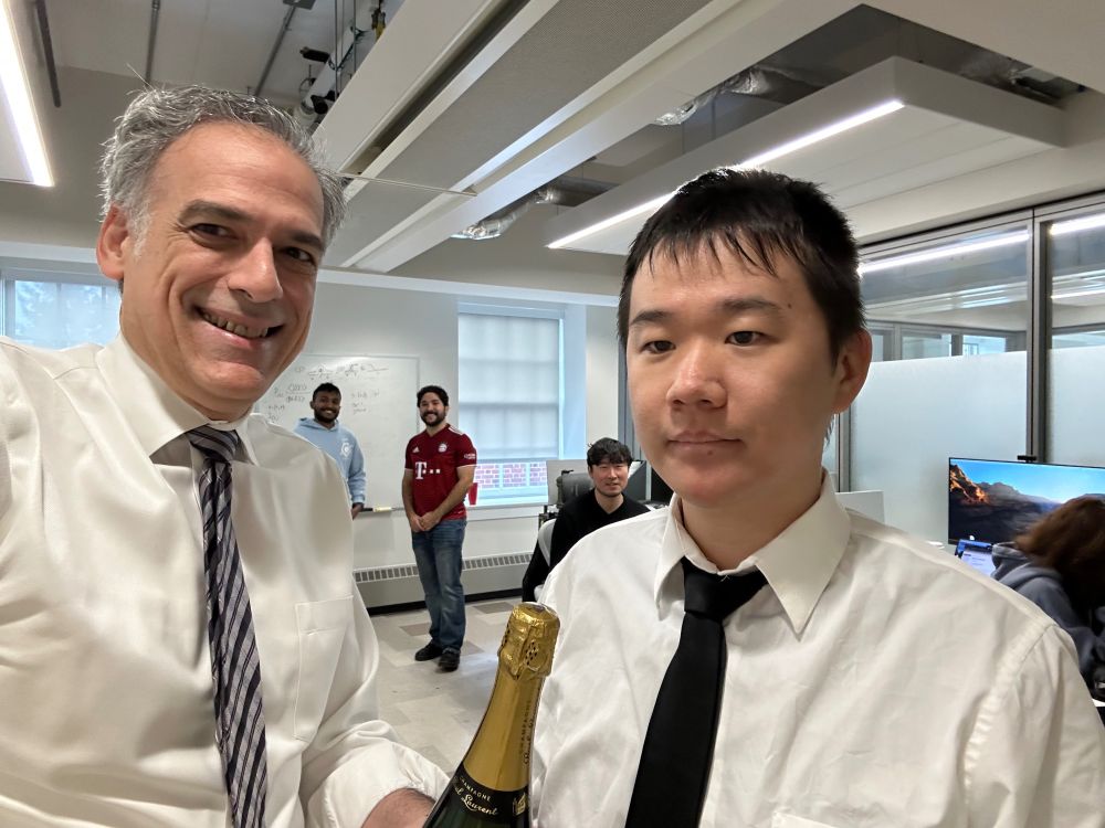 Two men in white shirts and ties holding a bottle of champaign